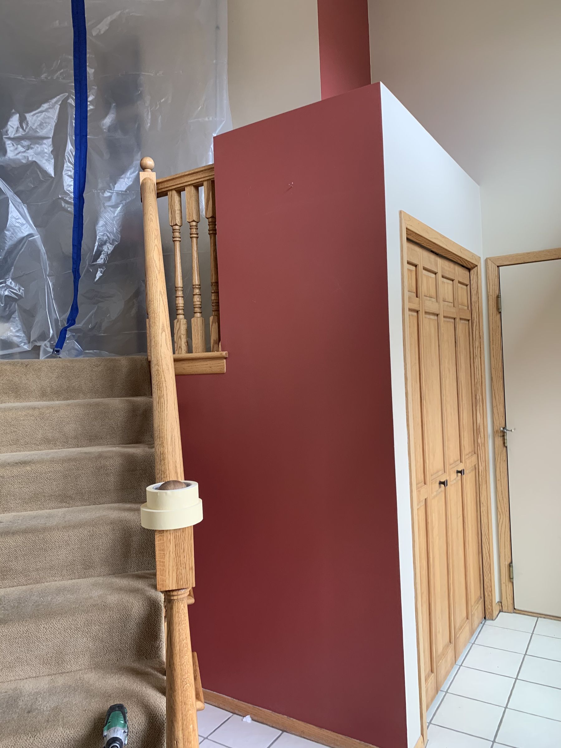 Before, the entry had a red accent wall, carpeted stairs, and oak spindles and trim