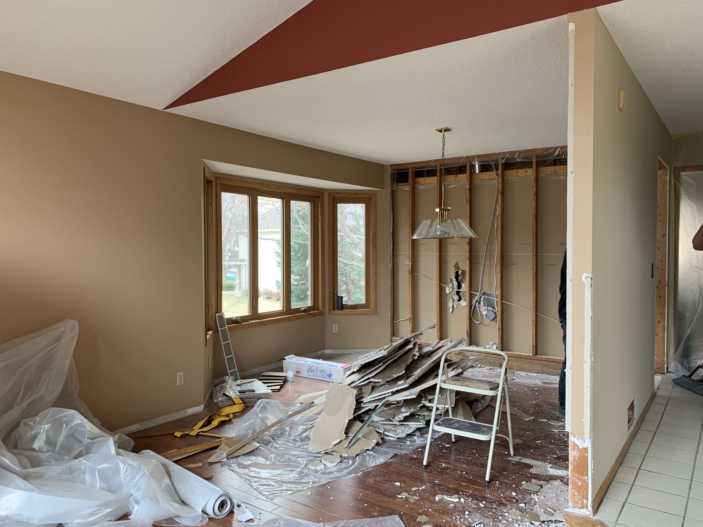 Demolition in the dining room, with the wall to the kitchen opened to the studs