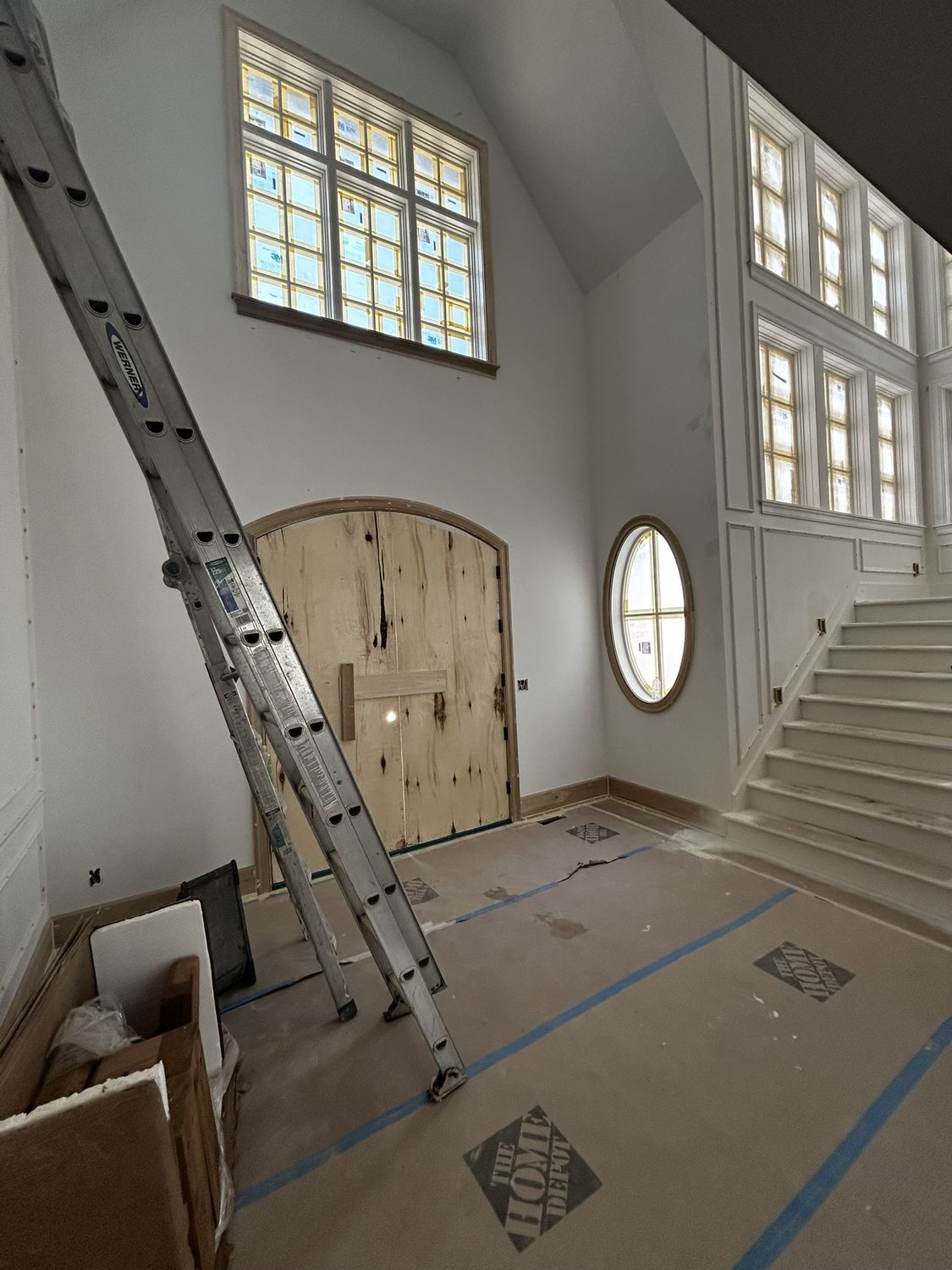 The foyer during construction, with protective covering on the arched front doors and floor